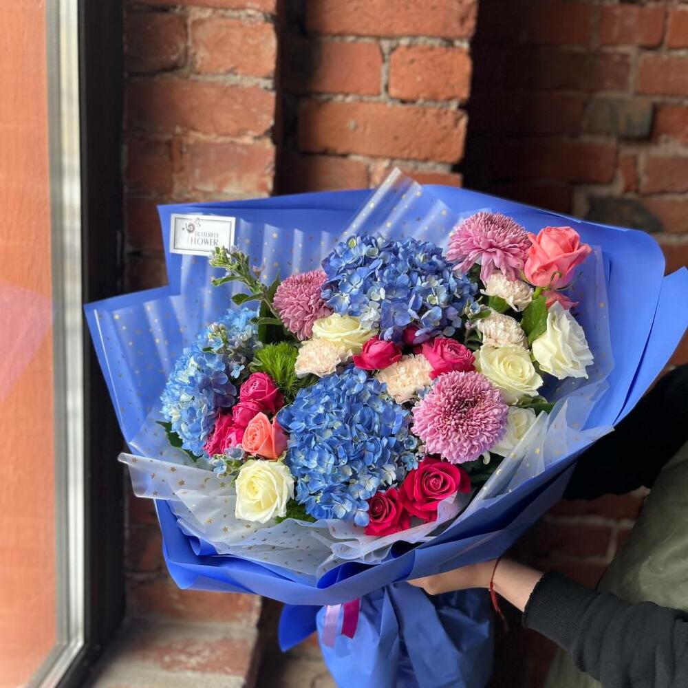 Букет из гортензии, хризантемы, гвоздики, оксипеталума и роз в стильной упаковке "Ласковый ветерок"